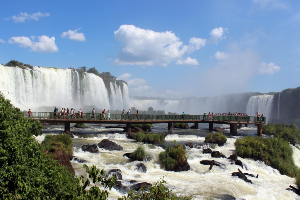 Crowds on a bridge with stunning views of the majestic Iguazu Falls in Brazil.